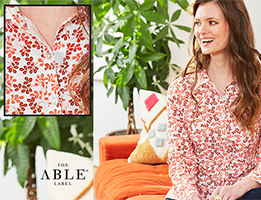 Photo of a woman wearing a floral shirt. There is an inset showing how the buttons are fastened.